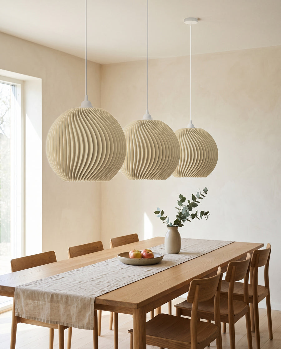Drei Onda Kugel-Lampenschirme in Beige in einer Reihe als Pendelleuchten über dem langen Esstisch, ausgeschaltet