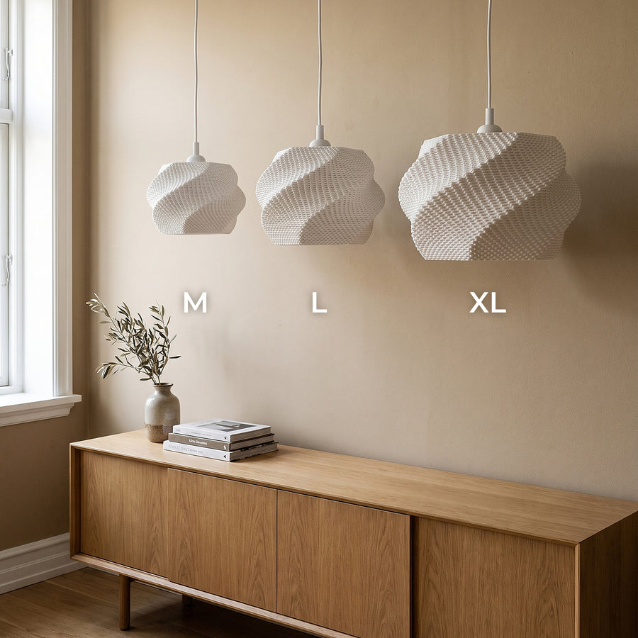 Wave Lampenschirm Weiß in drei Größen M, L und XL nebeneinander über dem Sideboard, ausgeschaltet